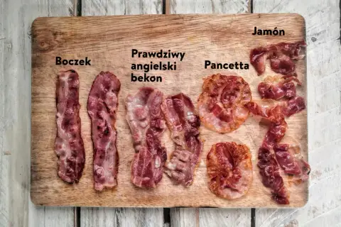 Boczek, prawdziwy angielski bekon, pancetta i jamón ułożone na desce. Różne rodzaje wędlin, każdy z nich ma swój unikalny wygląd.